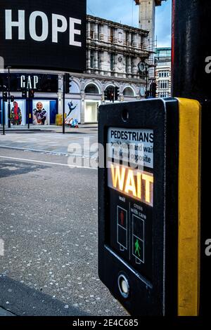 England, London. Januar 22nd 2021. Werbetafel und Fußgängerübergangswartschild kombinieren, um die aktuelle Situation unter Lockdown 3 zusammenzufassen. Stockfoto