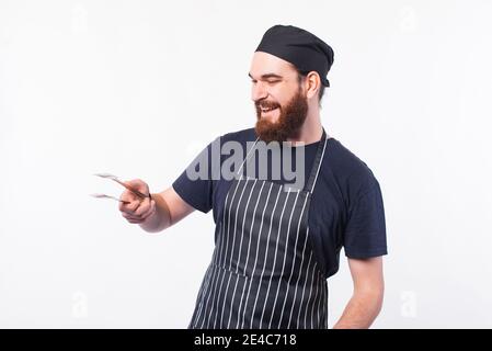 Koch Mann bereitet etwas Fleisch auf bbq auf weißem Hintergrund. Stockfoto