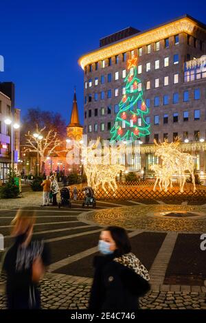 Bochum, Ruhrgebiet, Nordrhein-Westfalen, Deutschland - Weihnachtslichter in der Bochumer Innenstadt in Zeiten der Koronakrise im zweiten Teil der Schließung schmücken leuchtende Elchskulpturen den Dr.-Ruer-Platz, der Weihnachtsmarkt bleibt im Koronajahr geschlossen, die Pauluskirche im Hintergrund. Stockfoto