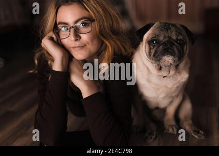 Schöne junge blonde weibliche Modell mit Mops Stockfoto