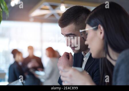 Zwei junge Business-Kollegen, männlich und weiblich, im Gespräch über neue Projekte an einer Kaffeebar Stockfoto