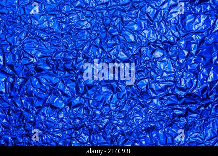 Heller blauer Folienhintergrund mit glänzend zerknitterter Oberfläche für Textur Hintergrund. Schillernde Oberfläche zerknittert Folie. Stockfoto