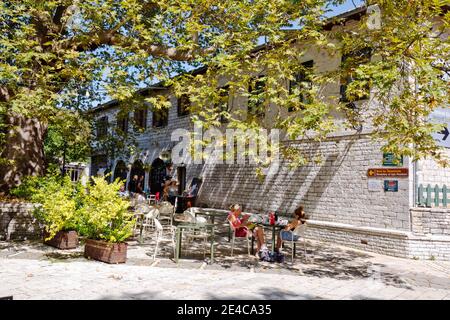 Eine Platane bietet Schatten auf der Terrasse im Restaurant in Monodendri, Zagori Dörfer, Pindus Berge, Epirus, Nordgriechenland Stockfoto