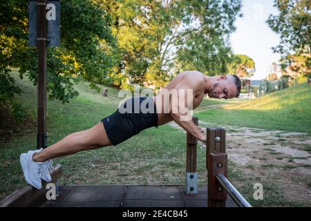 European Fitness Männer trainieren Liegestütze draußen an einer Bar in einem Park. Stockfoto