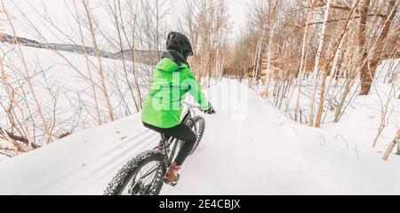 Fat Bike Winter Sport Biker Radfahrer Fahrrad Mädchen Reiten auf Schneepfad. Outdoor-Sport in der Natur Wald Hintergrund Panoramalandschaft Stockfoto