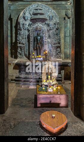 Lakkundi, Karnataka, Indien - 6. November 2013: Brahma Jinalaya Tempel. Nahaufnahme des inneren Heiligtums mit Idol-Statue und kleinem Geschenkaltar davor. Stockfoto