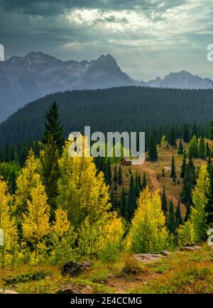 Eine Hütte erwartet einen entgegenkommenden Sturm nahe dem Molas Pass In Colorado sorgen bunte Herbstlaub der Aspen für Kontrast Stockfoto