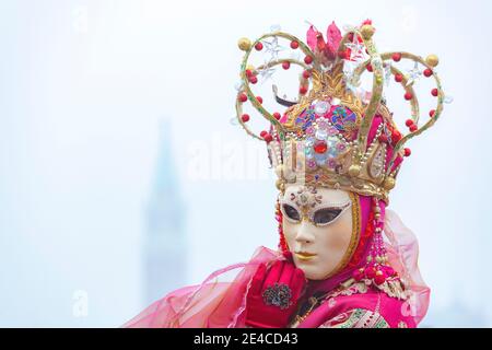 Italien, Venetien, Venedig, Frau im rosa Kleid Kostüm beim karneval in venedig, nebliger Morgen in der venezianischen Lagune Stockfoto