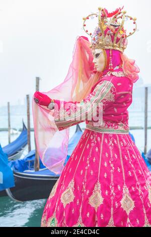 Italien, Venetien, Venedig, Frau im rosa Kleid Kostüm beim karneval in venedig, nebliger Morgen in der venezianischen Lagune Stockfoto