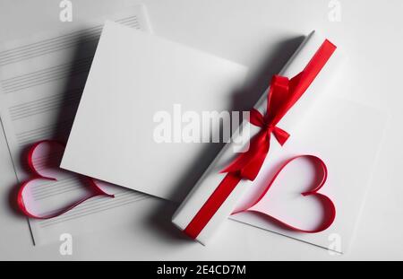 Postkarte, Geschenkbox mit rotem Band und Herzen auf weißem Hintergrund.14 Februar Valentinstag.Raum kopieren. Stockfoto