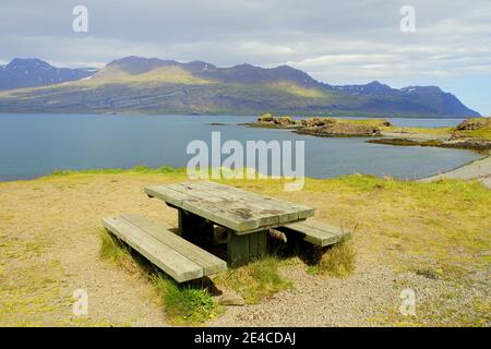 Ein Picknicktisch mit Blick auf die Berge am Meer in der Nähe von East Fjords, Island im Sommer Stockfoto