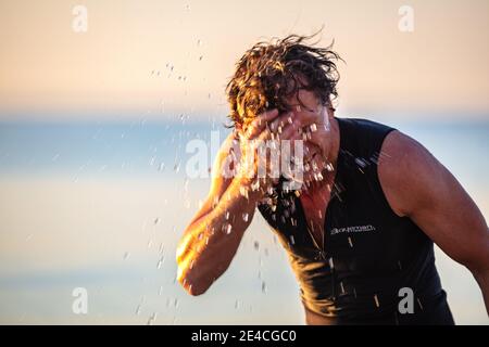 Man 50 plus fit, mit einem Neoprenanzug im Meer. Stockfoto