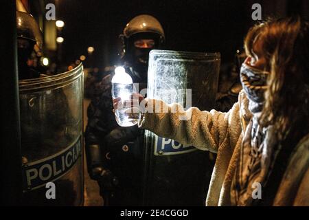 Ljubljana, Slowenien. Januar 2021. Ein Protestler bietet Polizisten eine Flasche Wasser an, während sie während der Demonstration in der Schlange stehen. Protest gegen die Räumung von Künstlern und sozialen Aktivisten aus einer ehemaligen Fahrradfabrik Rog, die seit über einem Jahrzehnt als besetztes alternatives soziales und kulturelles Zentrum genutzt wird. Die Räumung, die Anfang dieser Woche stattfand, beinhaltete den Abbruch eines sozialen Zentrums für marginalisierte und sozial gefährdete Menschen sowie eines Ressourcen- und Integrationszentrums für Migranten. Kredit: SOPA Images Limited/Alamy Live Nachrichten Stockfoto