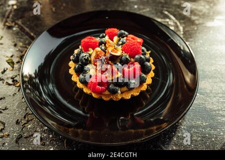 Nahaufnahme einer Tarte mit Erdbeeren und Heidelbeeren auf der Oberseite Stockfoto