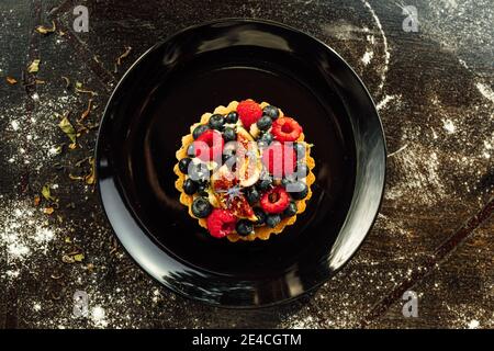 Nahaufnahme einer Tarte mit Erdbeeren und Heidelbeeren auf der Oberseite Stockfoto