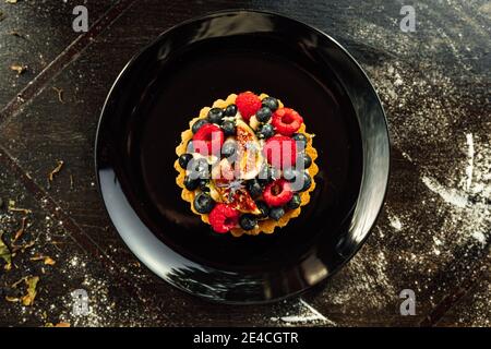 Nahaufnahme einer Tarte mit Erdbeeren und Heidelbeeren auf der Oberseite Stockfoto