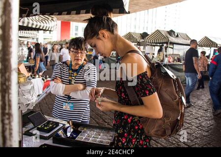 São Paulo / São Paulo / Brasilien - 08 19 2018: Hübsche Model-Frau, die einen Ring wählt, um auf einem Marktplatz zu kaufen, während die Verkäuferin zuschaut. Stockfoto