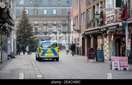 Düsseldorf, Nordrhein-Westfalen, Deutschland - Leere Düsseldorfer Altstadt mit Weihnachtsbaum in Zeiten der Koronakrise während des zweiten Teils der Sperre überprüfte eine Polizeistreife die leeren Straßen der Fußgängerzone. Stockfoto