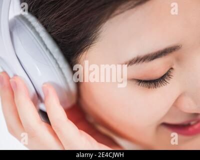 Junge Frauen hören Musik mit Kopfhörer Stockfoto