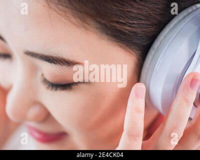 Junge Frauen hören Musik mit Kopfhörer Stockfoto