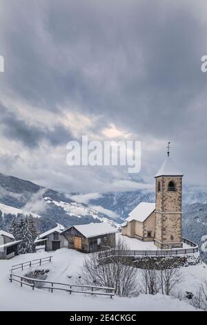 Italien, Venetien, Provinz Belluno, Comelico Superiore, Casamazzagno, die spätgotische Kirche von San Leonardo im Winter Stockfoto