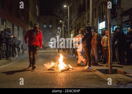 Barcelona, Spanien. Januar 2021. Der Protestierende sah während der Demonstration um ein Lagerfeuer herum. Die Wohnungsunion des Viertels Raval von Barcelona hat eine Demonstration aufgerufen, um Lösungen des stadtrates für Gebäude mit Bewohnern zu fordern, die unter Strom- und Wasserkürzungen leiden. Kredit: SOPA Images Limited/Alamy Live Nachrichten Stockfoto