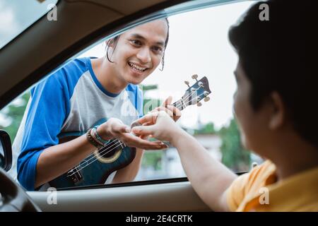 Straßenhändler erhalten von Hand, wenn jemand Münzen von der gibt Auto am Straßenrand Stockfoto