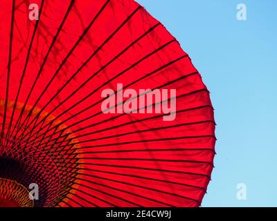 Ein roter Sonnenschirm gegen blauen Himmel in Tokio, Japan. Stockfoto