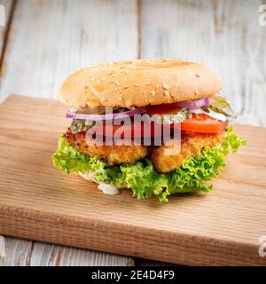 Nahaufnahme auf Zinger Burger mit frittiertem Huhn auf dem Holztisch Stockfoto