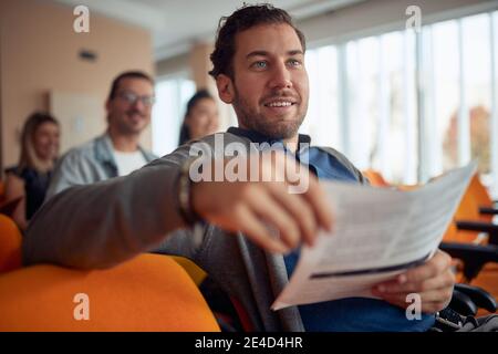 Junge kaukasische bärtigen Kerl lächelnd bei Business-Seminar, Stockfoto