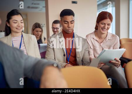 Multietchnic Gruppe von jungen Menschen auf Business-Seminar, Lesen von Skripten Stockfoto
