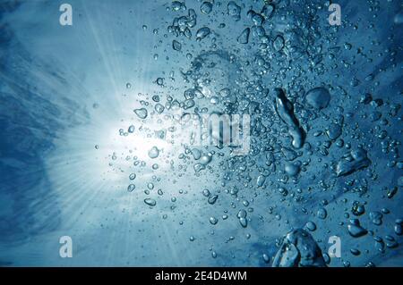 Luftblasen unter Wasser mit Sonnenlicht durch Wasseroberfläche, karibisches Meer Stockfoto