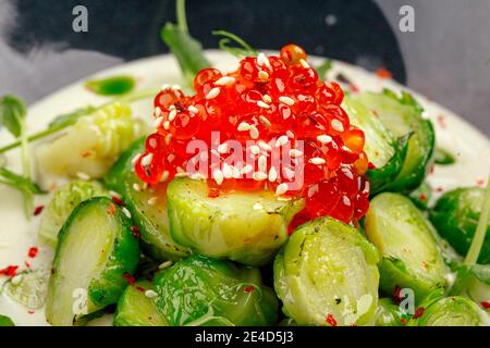 Rosenkohl mit Kaviar in einer schwarzen Schüssel Stockfoto