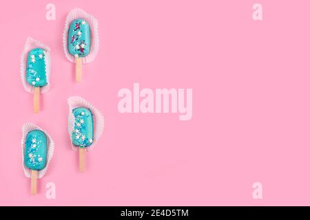 Leckeres und erfrischendes Eis auf Stöcken. Blaue Minze Eis-Eis-Eis-Eis-Eis auf pastellrosa Hintergrund. Minimales Sommerkonzept. Flach liegend. Stockfoto