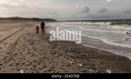 Thyboron, Dänemark - 23. Oktober 2020: Küstenlinie bei Thyboron an der dänischen Westküste, schöner Sandstrand, Menschen am Strand, Wolken am Himmel, w Stockfoto