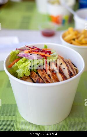 Gegrilltes Hähnchen mit Gemüse Nudelgericht in einer Papierschüssel. Koreanisch-asiatisches Essen Stockfoto