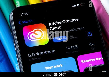 Mobile Adobe Creative Cloud-App im AppStore mit einem bunten Hintergrund aus Plastilin. Installation der Creative Cloud auf dem iPhone. Stockfoto