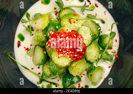 Rosenkohl mit Kaviar in einer schwarzen Schüssel Stockfoto