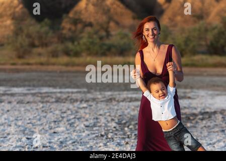 Mutter und kleiner Sohn haben gute Zeit in der Natur. Echte Menschen. Mutter und Kleinkind Sohn mit einem tollen Wochenende. Gemischte Rennfamilie Stockfoto