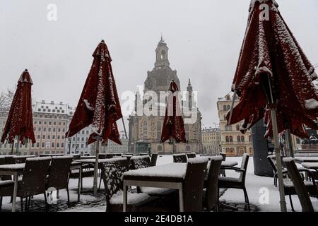 Dresden, Deutschland. Januar 2021. Verschneit sind Tische, Stühle und Sonnenschirme eines Restaurants auf dem Neumarkt vor der Frauenkirche. Quelle: Robert Michael/dpa-Zentralbild/dpa/Alamy Live News Stockfoto