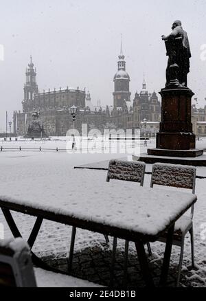 Dresden, Deutschland. Januar 2021. Morgens schneit es auf dem Theaterplatz mit der Hofkirche (l-r), der Reiterstatue von König Johann, dem Hausmannsturm, dem Residenzschloss, der Schinkelwache, dem Carl Maria von Weber Denkmal und dem Zwinger. Quelle: Robert Michael/dpa-Zentralbild/dpa/Alamy Live News Stockfoto