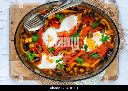 Shakshuka - klassisches nordafrikanisches und nahöstliches Gericht Pochierte Eier in gewürzter Tomaten- und Pfeffersauce Stockfoto