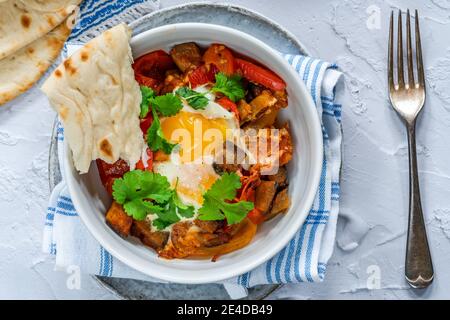 Shakshuka - klassisches nordafrikanisches und nahöstliches Gericht Pochierte Eier in gewürzter Tomaten- und Pfeffersauce Stockfoto