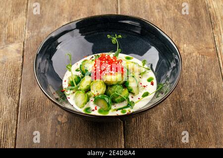 Rosenkohl mit Kaviar in einer schwarzen Schüssel Stockfoto