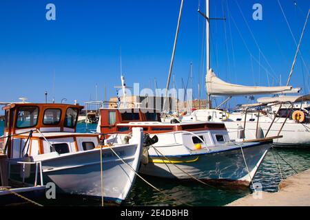 Heraklion, Griechenland - 16. August 2020 - Boote im historischen Hafen von Heraklion mit der historischen Festung Koules im Hintergrund Stockfoto