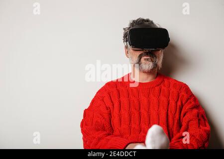 VR-Brille mit virtueller Realität, gesehen von dem zu Hause sitzenden Mann. Stockfoto