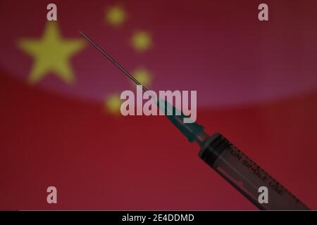 Spritze auf Flagge von China Hintergrund. Covid-19 Impfkonzept. Unscharfer Hintergrund. Stockfoto