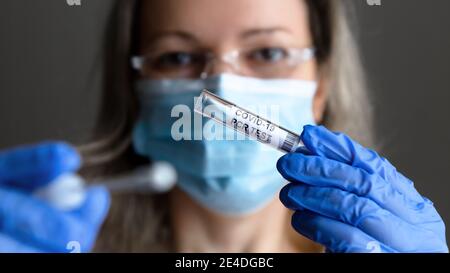 COVID-19 Test in Arzthand Nahaufnahme, Frau in medizinische Maske will Speichel und Nasenproben für Coronavirus PCR-Tests nehmen. Konzept der Corona vi Stockfoto