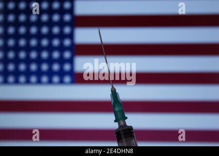 Spritze auf Flagge von USA Hintergrund. Covid-19 Impfkonzept. Unscharfer Hintergrund. Stockfoto