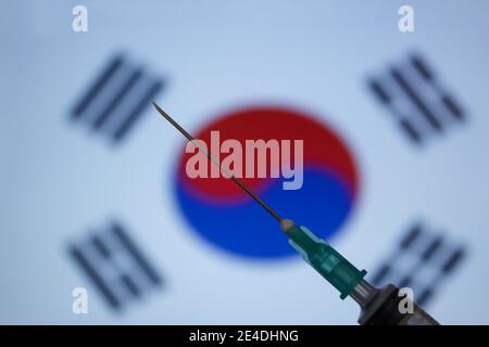 Spritze auf Flagge von Südkorea Hintergrund. Covid-19 Impfkonzept. Unscharfer Hintergrund. Stockfoto